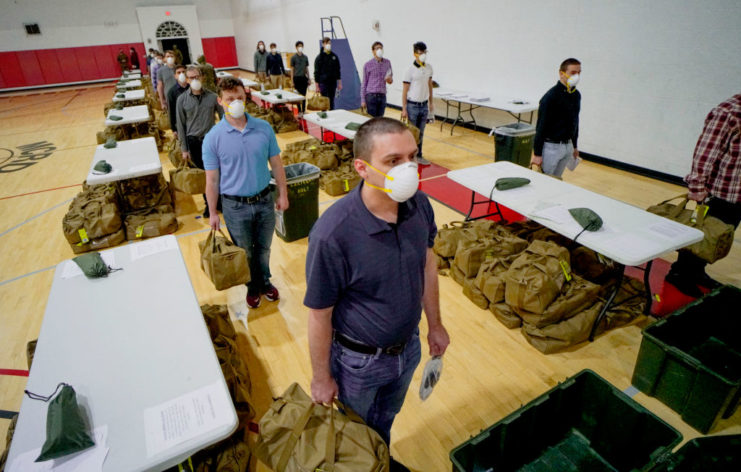 Male military recruits walking between tables