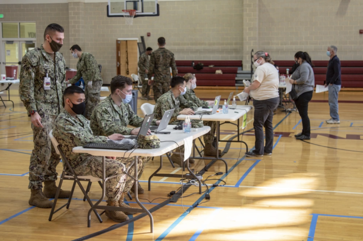 Soldiers sitting at tables with laptops