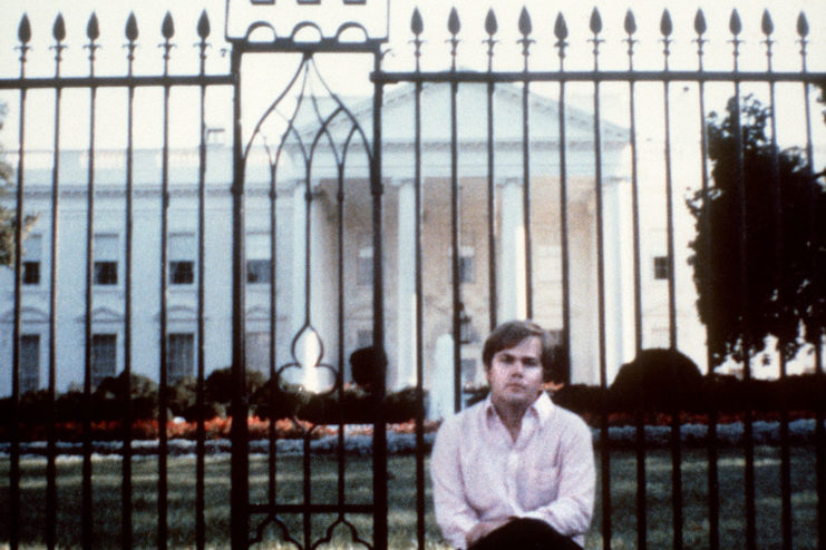 John Hinckley Jr. sitting in front of the White House gates