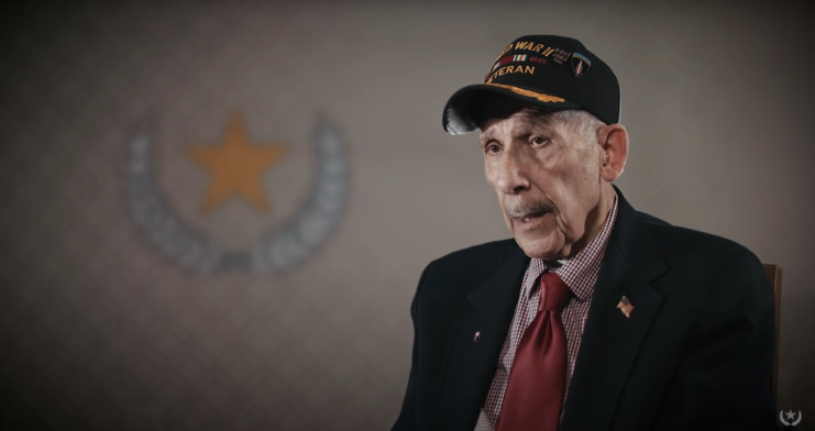 Louis Graziano wearing a suit and baseball cap