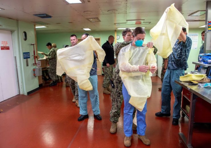 Soldiers putting on protective medical gear