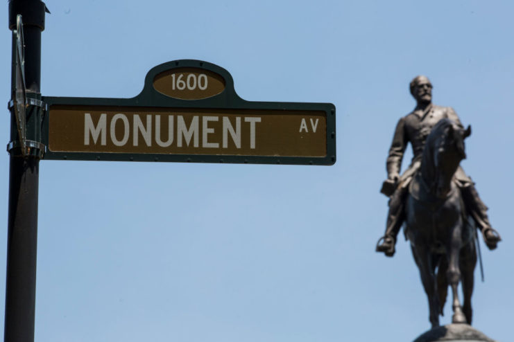 Monument Avenue sign with the statue of Robert E. Lee in the background