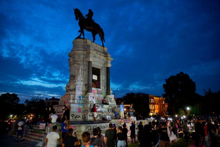 Protestors surround the Robert E. Lee statue at night