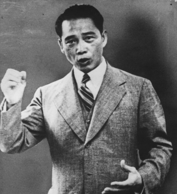 Wang Jingwei holding up his fist while talking