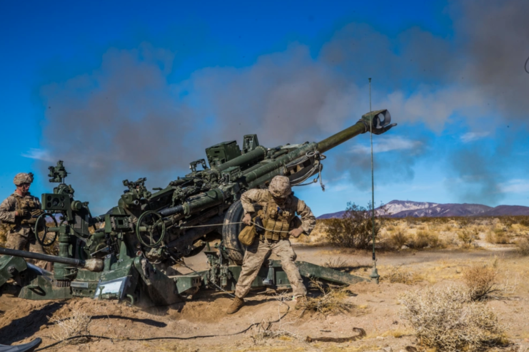 Two Marine firing a M777 Howitzer