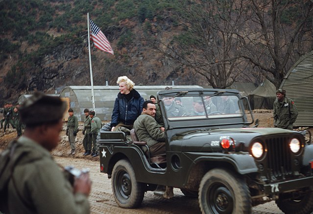 Marilyn Monroe riding in a military Jeep