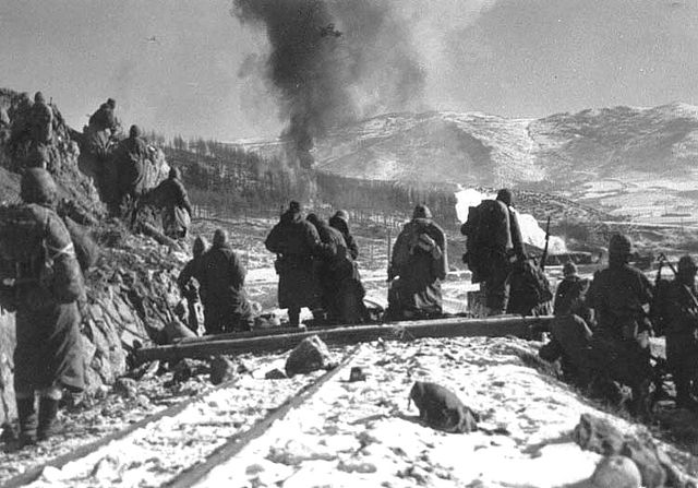 US soldiers watching as smoke rises into the air