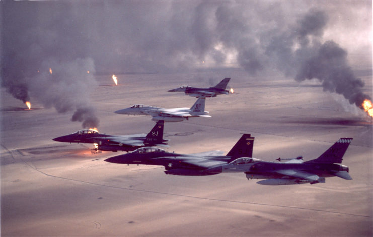 Fighter jets flying over burning oil fields