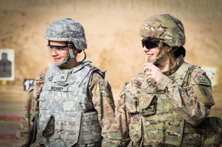 Two female service members in combat uniform