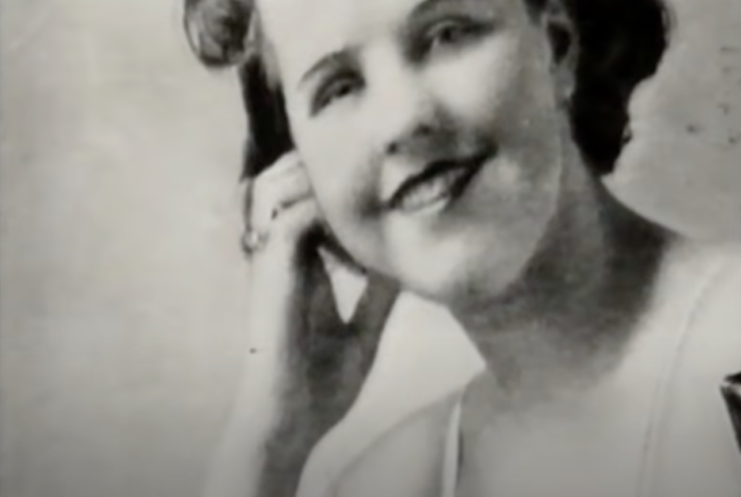 Evelyn Oatley smiling with her hand on her cheek