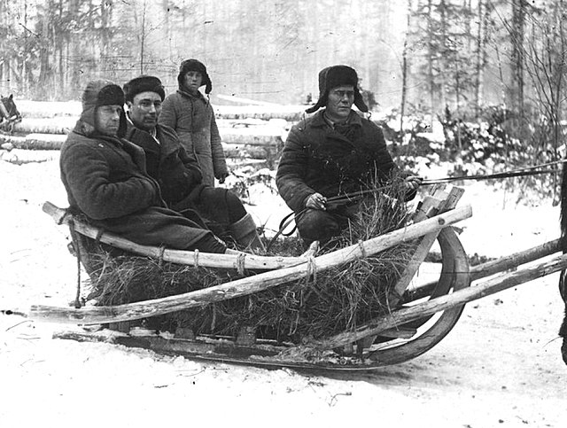 Four male prisoners sitting in a sled