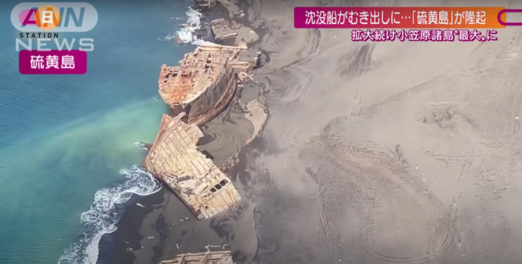 Broken ship hulks spread across the shore of Iwo Jima