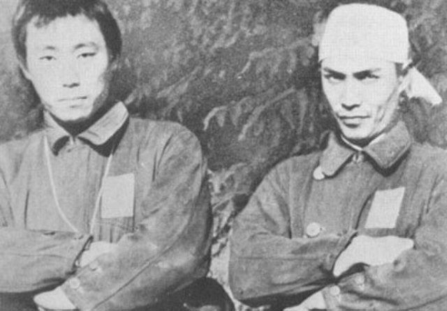 Lt. Hiroshi Kuroki and Lt. Sekio Nishina standing with their arms crossed