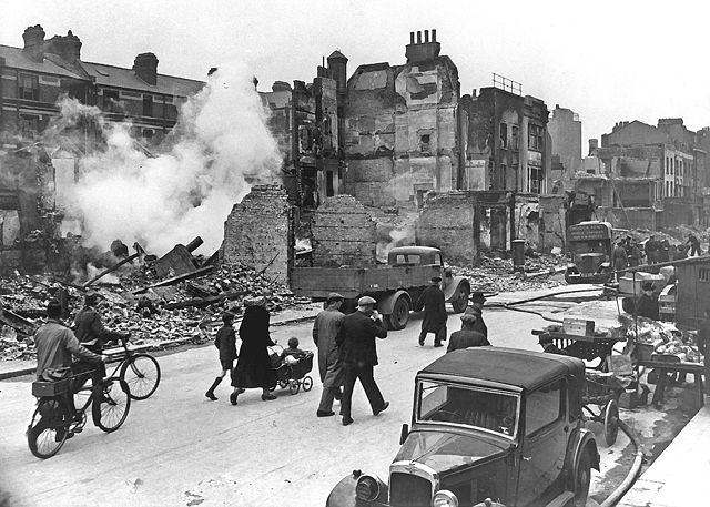 People walking around crumbling buildings