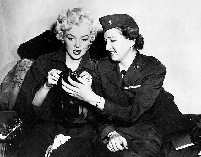 A female soldier teaching Marilyn Monroe how to use an oxygen mask