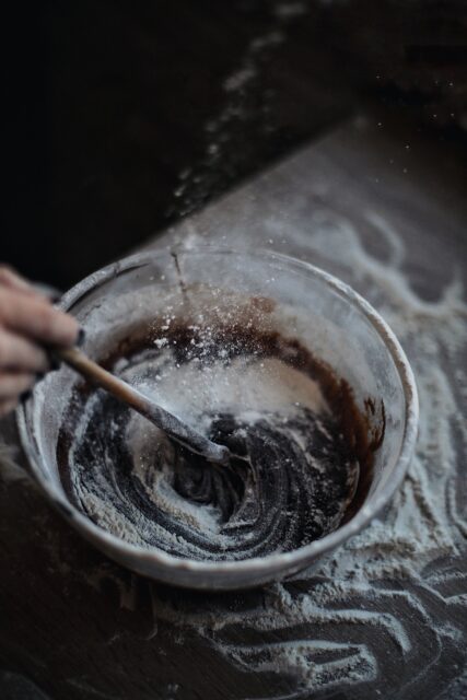 Hand stirring batter in a mixing bowl