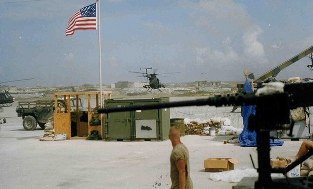 Service member watching a helicopter take off from base