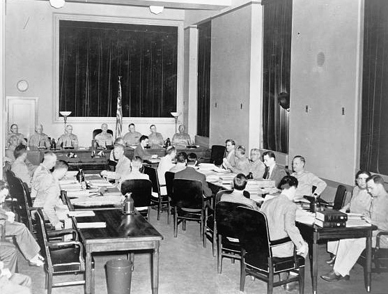 Defendants, lawyers and judges sitting at tables in a room