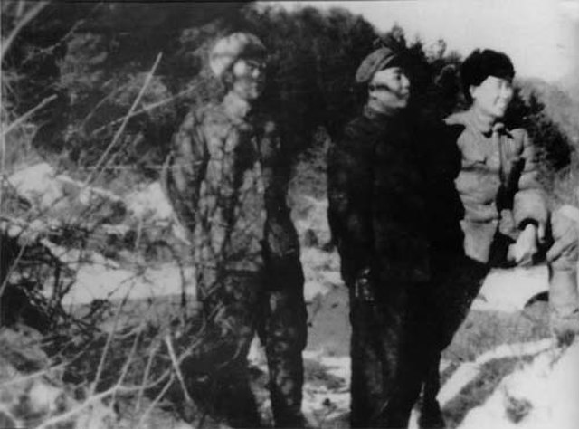 Three soldiers with the People's Volunteer Army standing in the snow