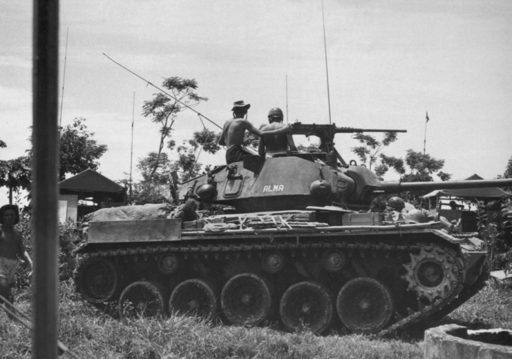 French soldiers sitting on top of a tank