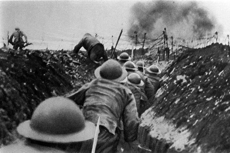 Soldiers walking through a trench during battle