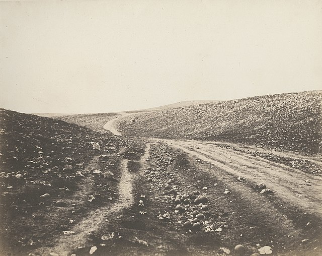 Dirt road strewn with the remains of cannon shells