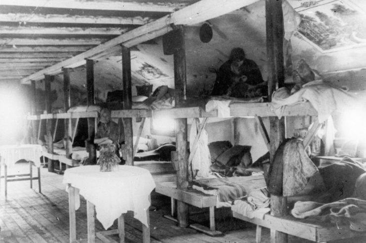 Prisoners sitting on wooden bunkbeds