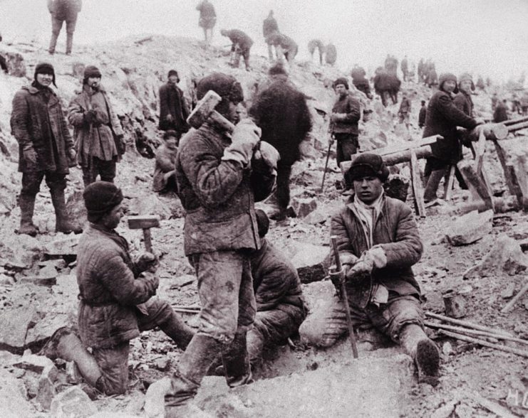 Male prisoners gathered around a construction site