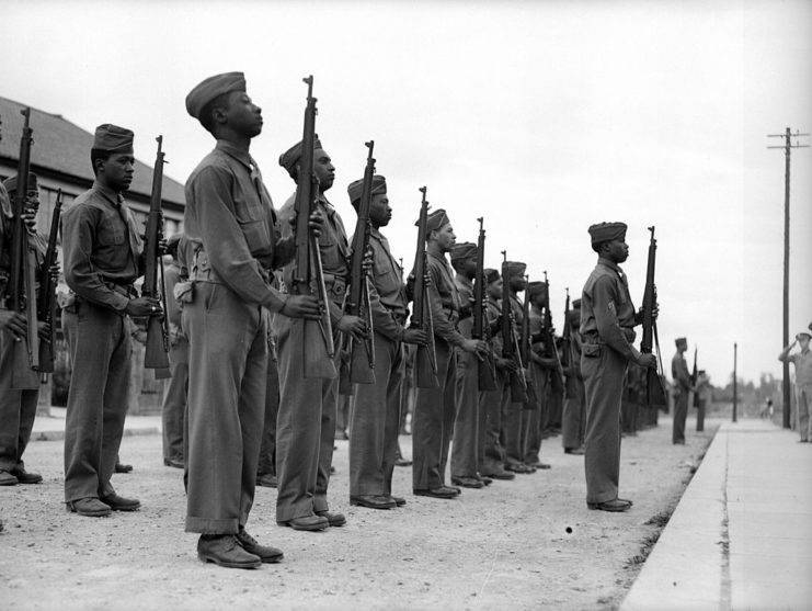 African American troops standing at attention with rifles in their hands
