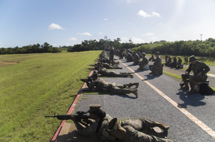 US Marines lying on the ground while aiming rifles