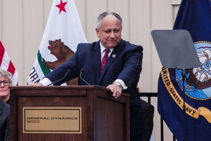 Carlos Del Toro standing behind a podium