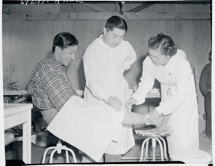 Japanese-American man being treated by two doctors
