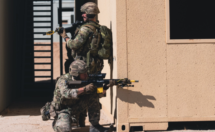 Two members of the Royal Marines providing security at the corner of a building