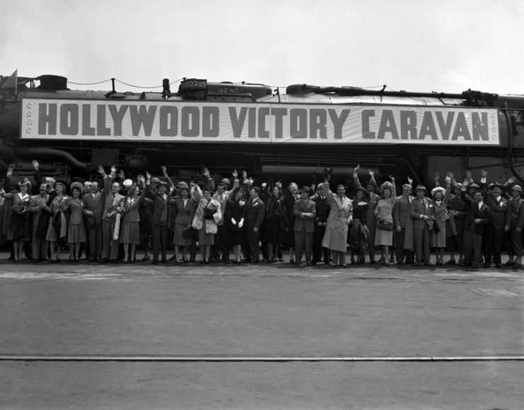 Members of the Hollywood Victory Caravan standing under a sign advertising the event