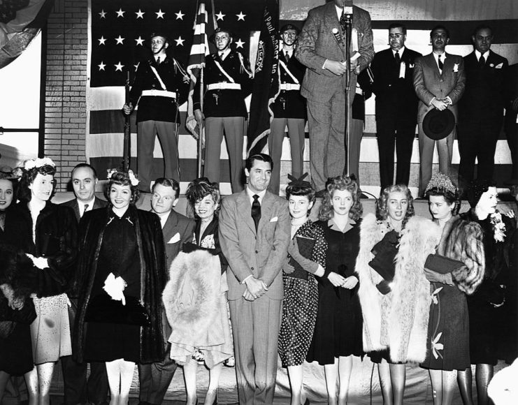 Group of movie stars standing in front of a theater stage