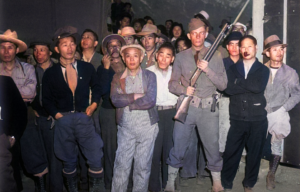 Japanese-Americans being guarded by an American soldier