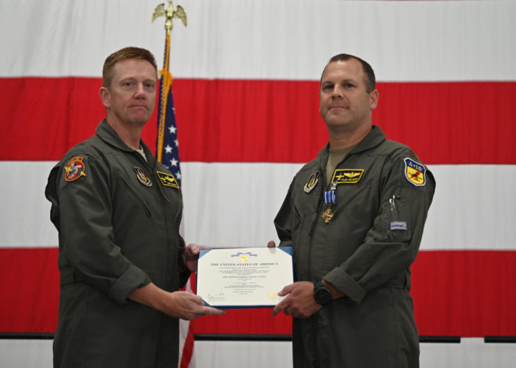 US Air Force personnel presenting Major Mike "Vago" Hilkert with a certificate