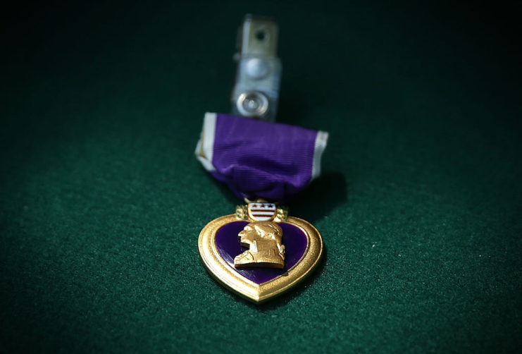 A Purple Heart medal against a green backdrop
