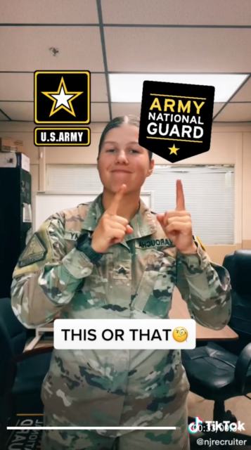 Sergeant Georgia Varoucher pointing toward the US Army National Guard insignia