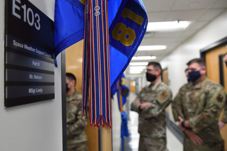 US Air Force personnel standing outside a classroom door