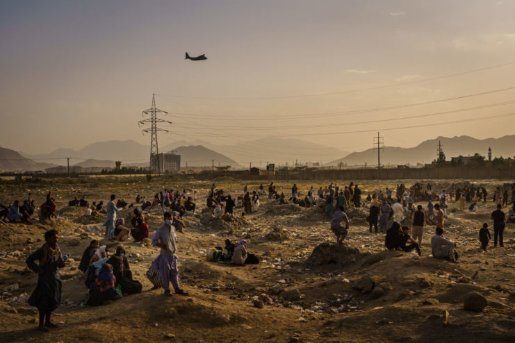 Citizens watch as a plane flies overhead during the US withdrawal from Afghanistan