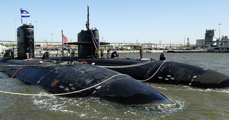 The USS Newport News and the USS Boise parked beside each other in the water