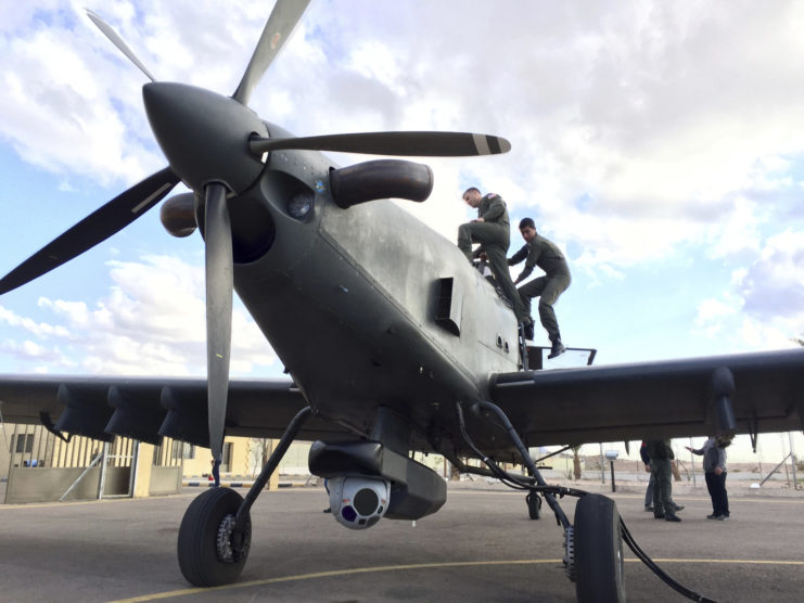 Combat Aviation Advisors standing atop a grounded airplane