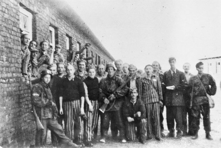 Members of Battalion Zośka standing with inmates near a brick building
