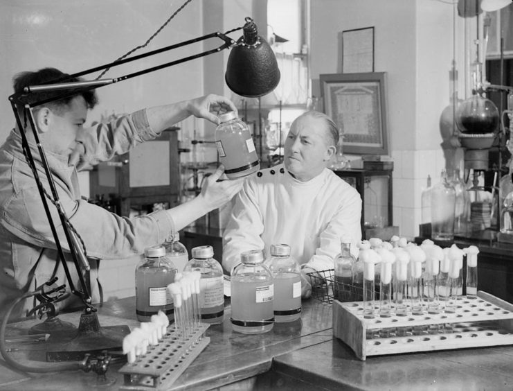 Two doctors examining a bottle of plasma