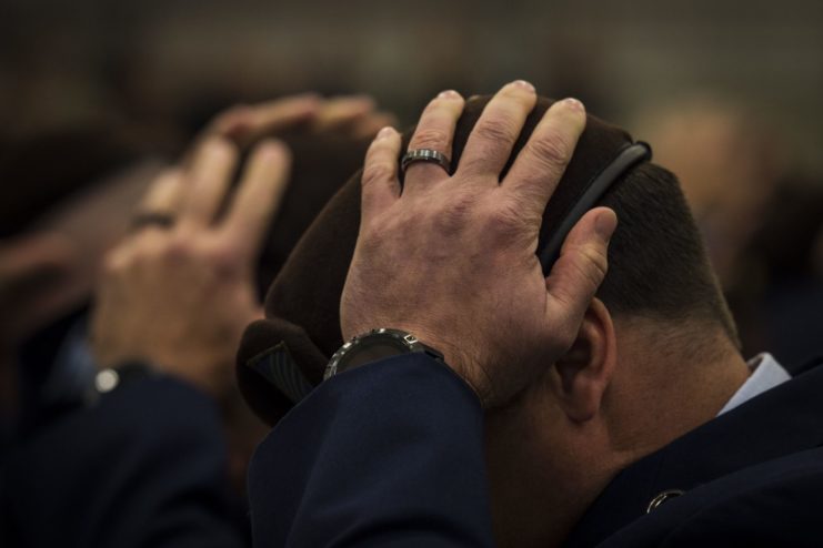 Combat Aviation Advisors placing their hands on their brown berets