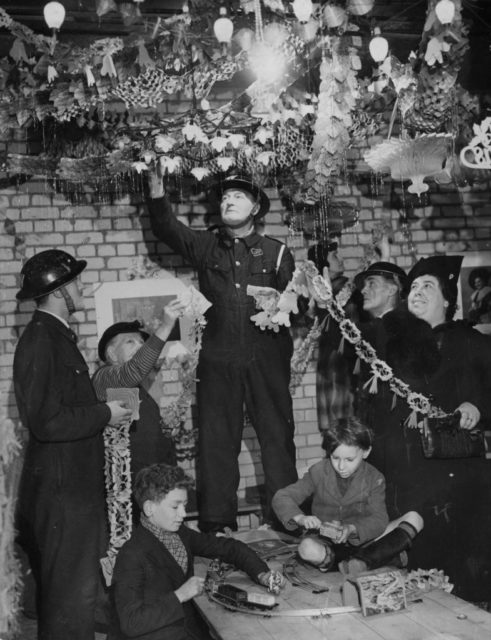 Air Raid Patrol members hanging Christmas decorations in an underground shelter