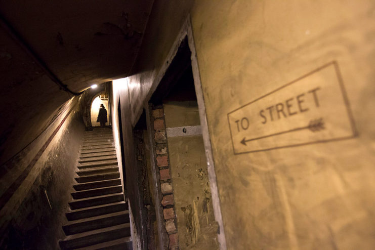 Woman walking up a stairway leading to the exit of Down Street Tube Station