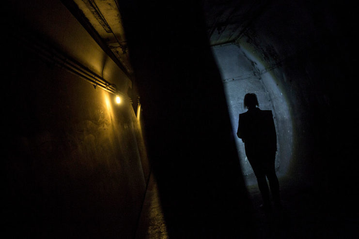 Woman's shadow against a dimly-lit wall