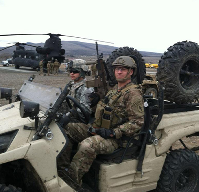 Earl Plumlee sitting in a military vehicle while in combat uniform